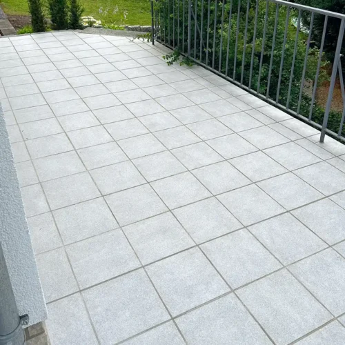 Boden des Balkons nach der Balkonsanierung mit hellgrauen quadratischen Fliesen